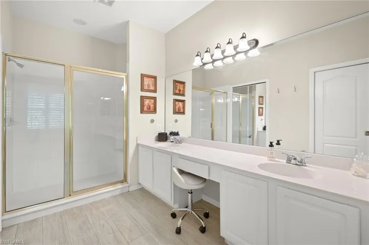 Double vanity, shower, plank tile floors.