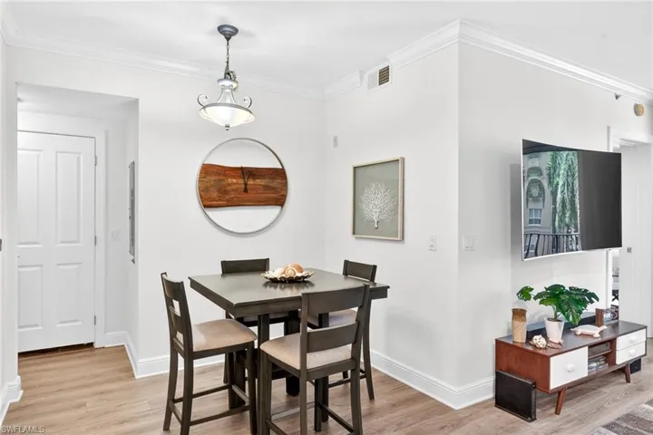 Dining room featuring light wood-type flooring and crown molding