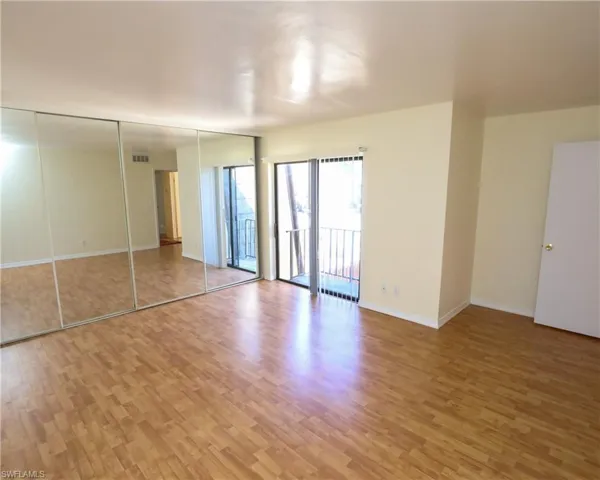 Unfurnished bedroom with a closet, access to exterior, and light wood finished floors