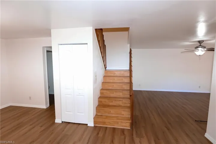 Staircase with ceiling fan and wood finished floors