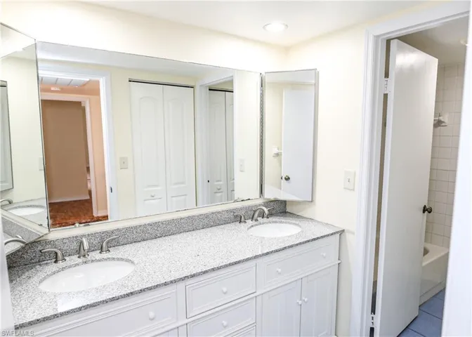 Bathroom with a closet, double vanity, shower / washtub combination, tile patterned floors, and recessed lighting