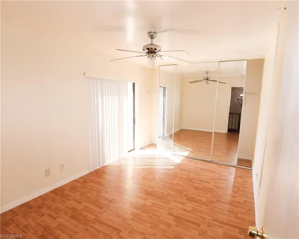 Unfurnished bedroom with wood finished floors, a closet, and ceiling fan