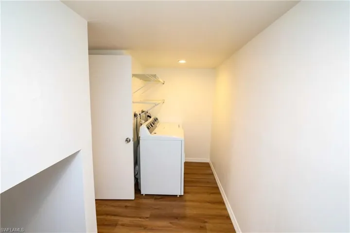 Laundry area with wood finished floors, recessed lighting, and independent washer and dryer