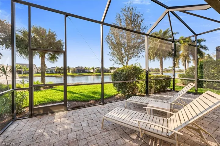 View of patio with a water view, a lanai, a sunroom, and a residential view