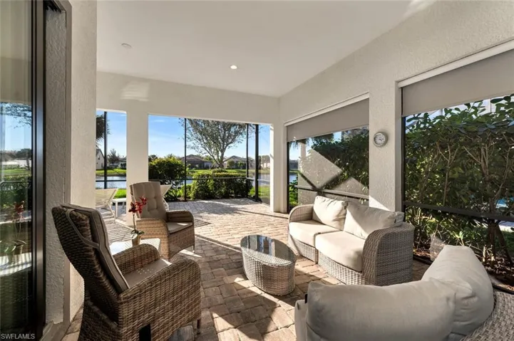Sunroom / solarium with a textured wall, a water view, and recessed lighting