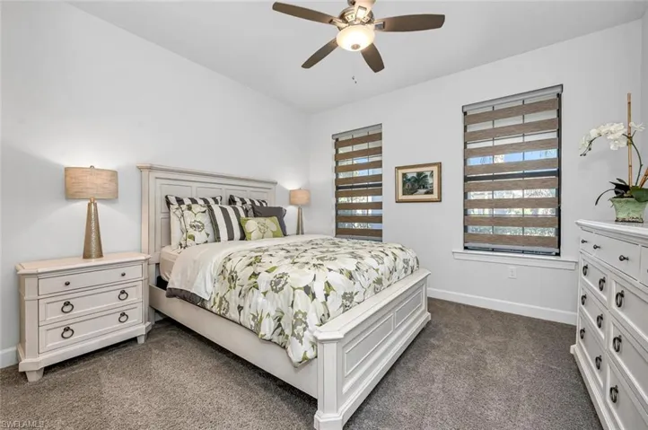 Bedroom with dark carpet and ceiling fan