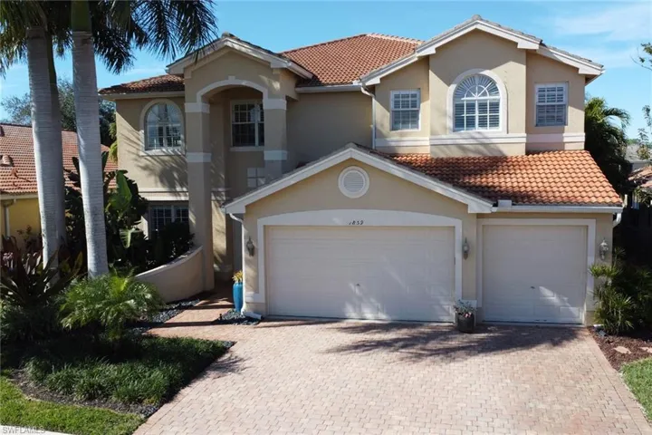 Mediterranean / spanish house featuring a tile roof, decorative driveway, and stucco siding