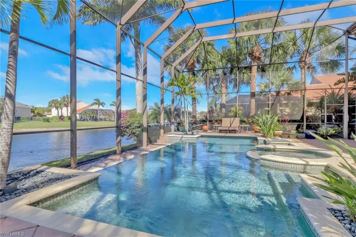 View of swimming pool with a pool with connected hot tub, a patio area, a water view, glass enclosure, and a sunroom