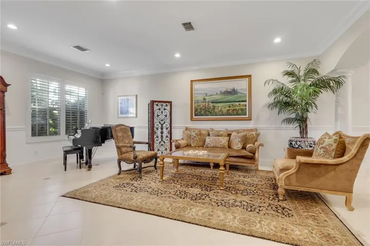 Living room with ornamental molding, recessed lighting, and tile patterned floors
