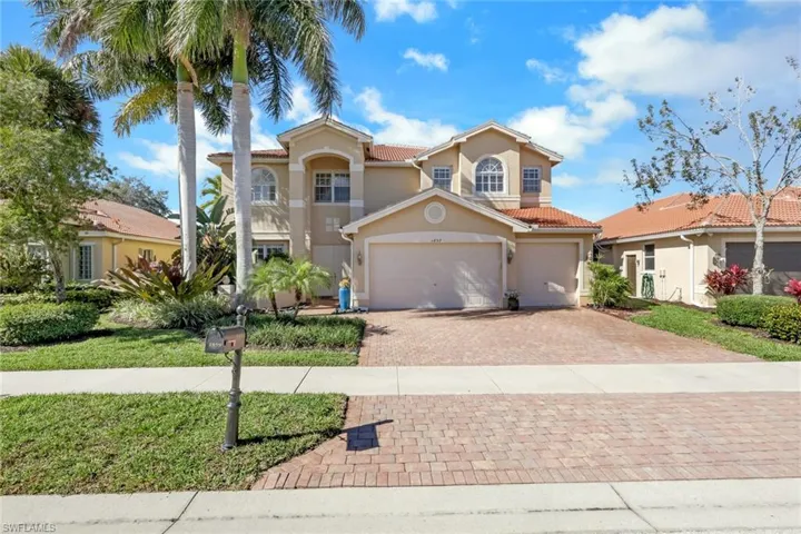 Mediterranean / spanish-style home with a tiled roof, decorative driveway, stucco siding, a garage, and a front lawn