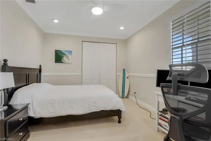 Bedroom featuring light colored carpet, a closet, crown molding, recessed lighting, and a desk