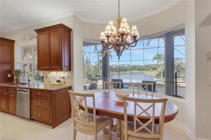 Dining space featuring ornamental molding, a chandelier, light tile patterned flooring, and a water view