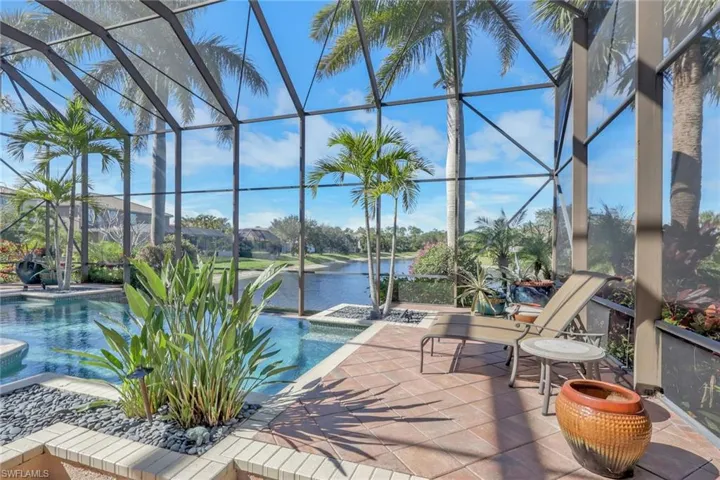 View of swimming pool with a sunroom, a lanai, a water view, a patio, and a pool with connected hot tub