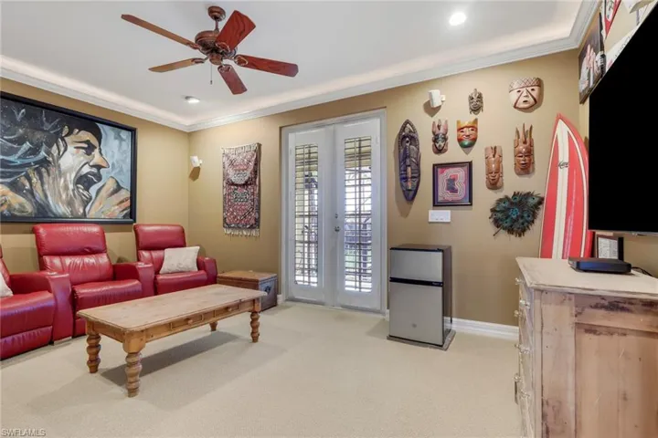 Living room featuring light carpet, french doors, crown molding, and a ceiling fan