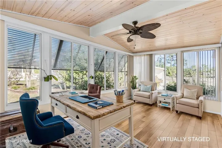 Home office with vaulted ceiling with beams, light wood finished floors, wood ceiling, and ceiling fan