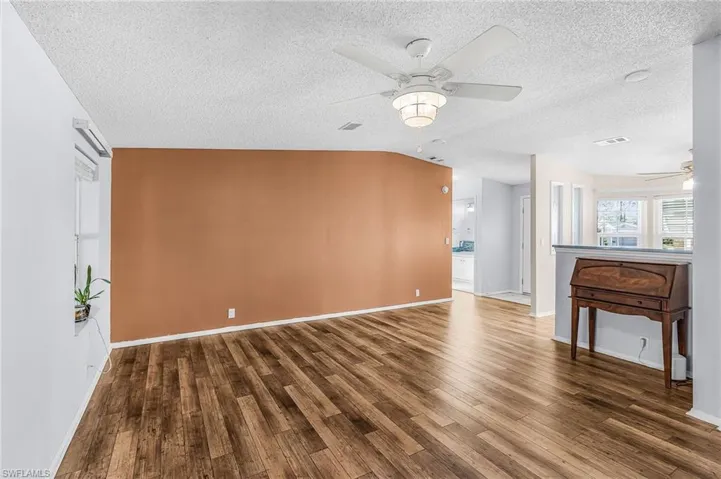 Unfurnished living room with ceiling fan and dark wood-style floors