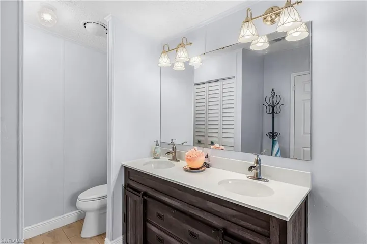 Bathroom featuring double vanity and a textured ceiling