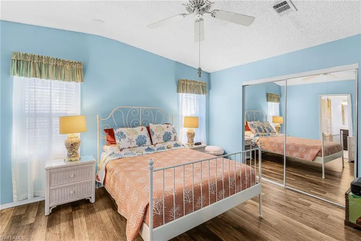 Bedroom featuring hardwood / wood-style flooring, ceiling fan, a closet, and a textured ceiling