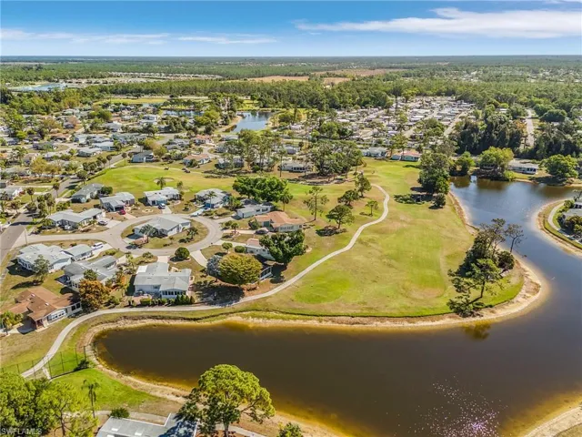 Aerial view of property and surrounding area with a large body of water, nearby suburban area, and a golf club