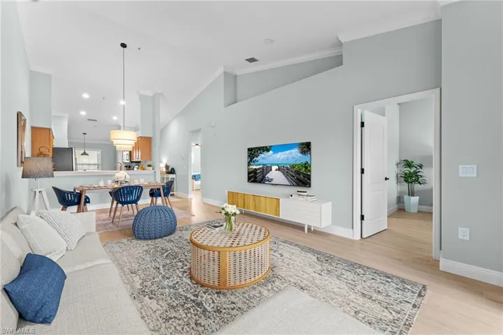 Partially Virtually Staged. Gorgeous wood oak plank tiles througout with 5 1/4" baseboards. Soaring cathedral ceilings, crown molding, professionally painted - ALL combine for an elevated, updated condo!. Opens to primary bedroom.
