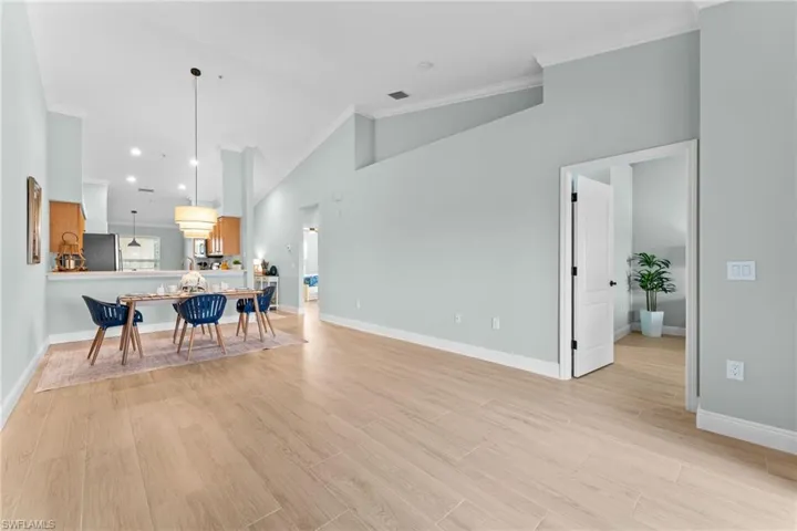 Gorgeous wood ook plank tiles througout with 5 1/4" baseboards. Soaring cathedral ceilings, crown molding, professionally painted - ALL combine for an elevated, updated condo!. Opens to primary bedroom.