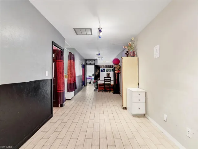 Hallway featuring wood finish floors and baseboards