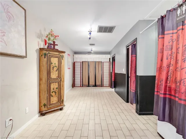 Hallway with light wood-style floors and baseboards
