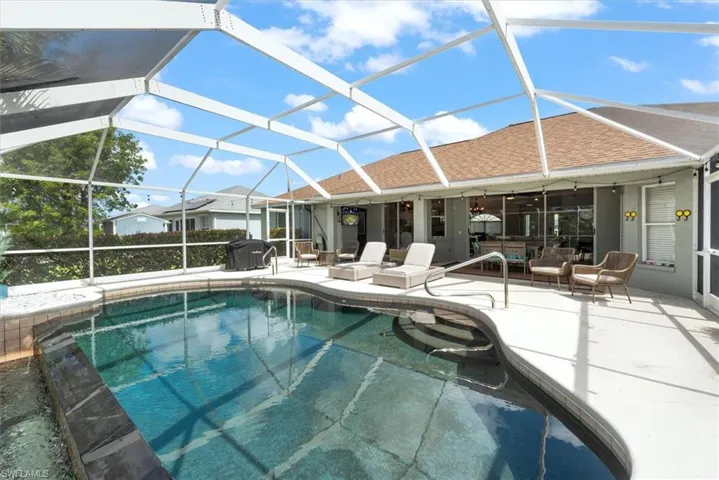 Outdoor pool featuring an outdoor living space, a patio, glass enclosure, and ceiling fan