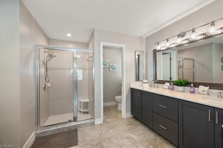 Bathroom featuring double vanity and a stall shower