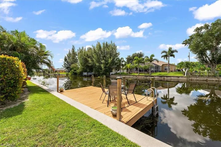 Dock featuring a water view, a yard, and a residential view