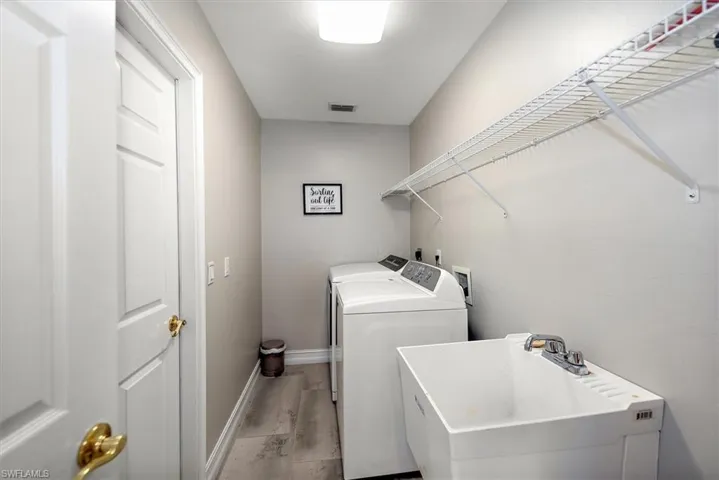 Laundry room featuring separate washer and dryer and light wood-style floors