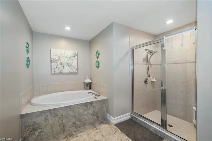 Bathroom featuring a garden tub, a stall shower, recessed lighting, and tile patterned flooring