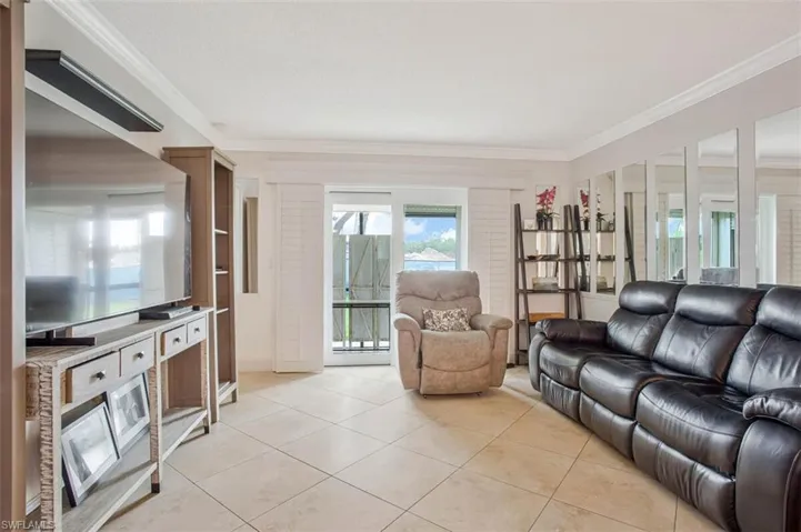 Tile flooring, crown molding, built-in shelving, vertical slat window treatments, and a glass-paneled door