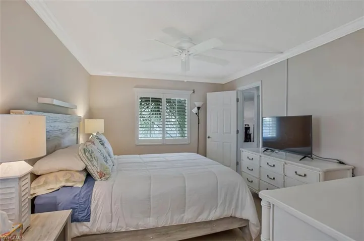 Crown molding accenting the ceiling, plantation shutters, and a ceiling fan with integrated lighting  Ensuite
