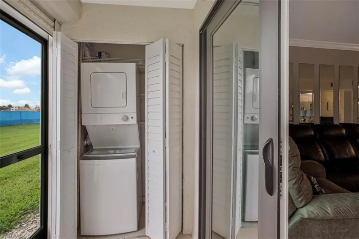 Built-in laundry closet with louvered bi-fold doors and a stacked washer and dryer