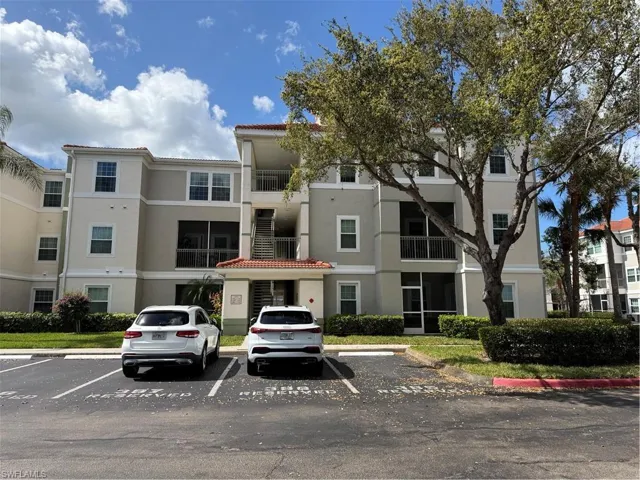 View of apartment building / complex featuring uncovered parking