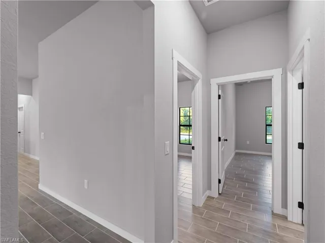Hall with baseboards and wood finished floors