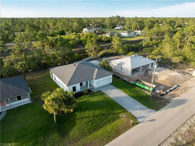 Aerial view of property and surrounding area featuring a heavily wooded area