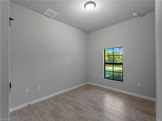 Unfurnished room with wood tiled floors, baseboards, and a smoke detector