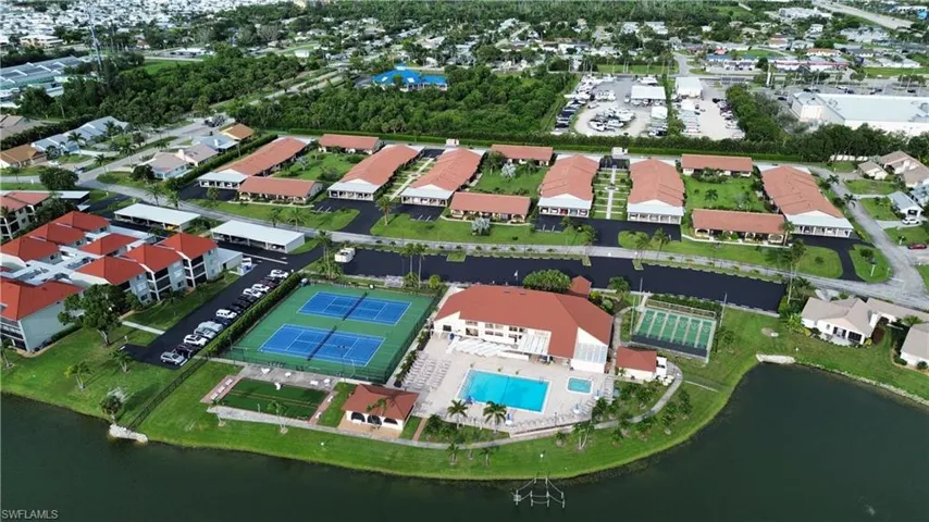 Aerial view of property and surrounding area featuring a pool area and a nearby body of water