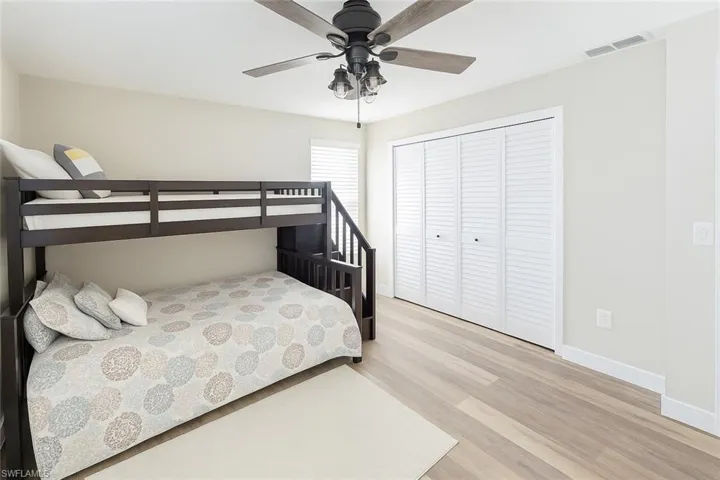 Bedroom with light wood finished floors, a closet, and ceiling fan