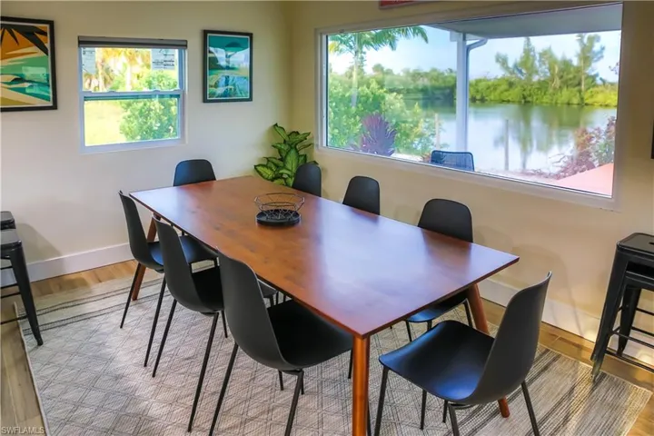 The dining area, bathed in natural light from nearby windows, offers scenic views of the LAKE, creating the ideal setting for meals.