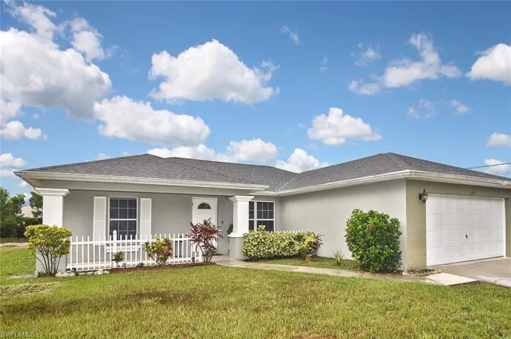 Ranch-style house featuring a garage, a front yard, and a porch