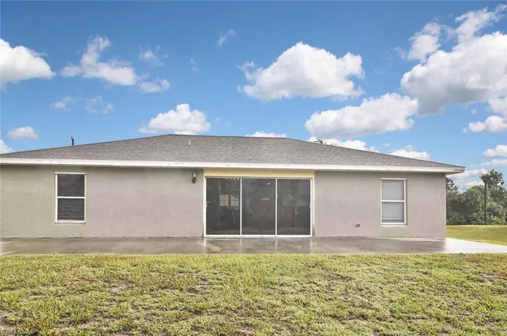 Rear view of house featuring a lawn and a patio