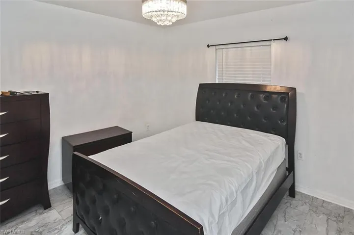 Tiled bedroom with a notable chandelier