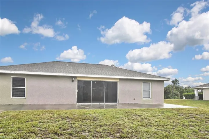 Rear view of house with a patio and a yard