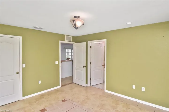Unfurnished bedroom with light tile floors