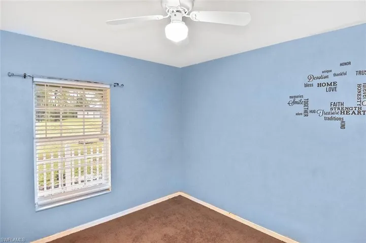 Carpeted spare room with ceiling fan