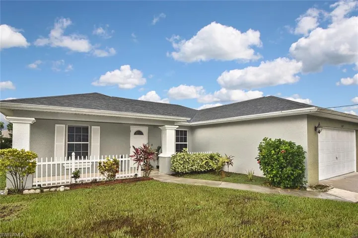 Ranch-style house with a garage, a front yard, and covered porch