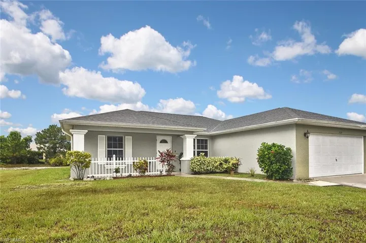 Ranch-style home featuring a garage and a front lawn